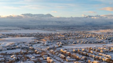 Utah Vadisi 'nde Sunset' te, dağ manzaralı karlı bir mahallede evleri olan bir manzara.