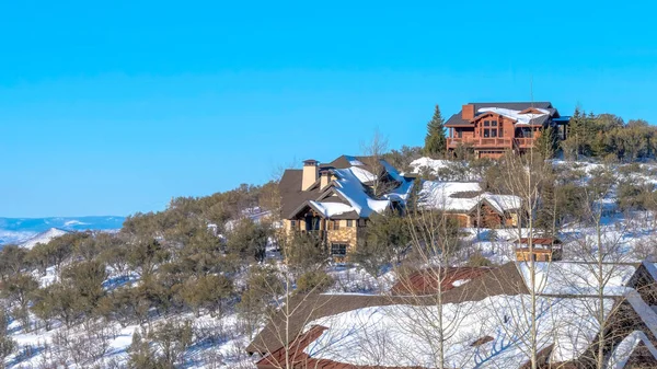 Panorama Park City Utah winter landscape with homes on a mountain top against blue sky