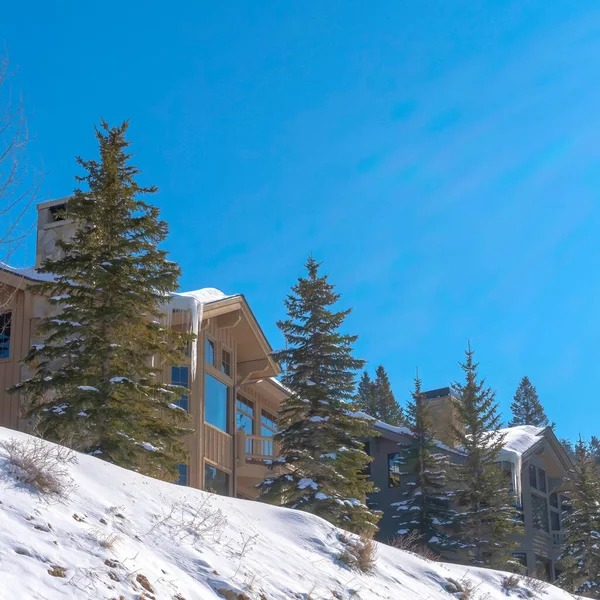 Négyzet Arculata gyönyörű otthonok egy fehér havas lejtőn egy napsütéses téli napon — Stock Fotó