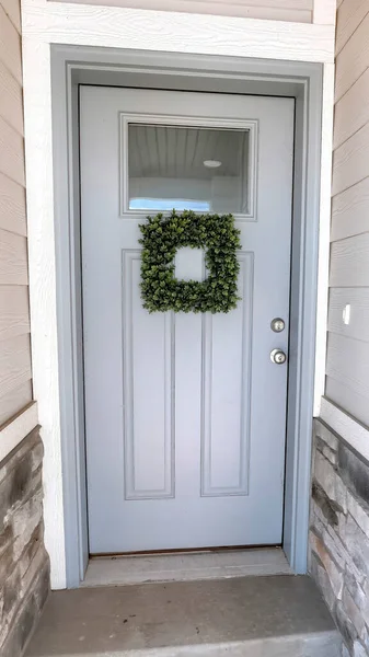 Vertical Square leafy wreath on front door entrance with glass pane and transom window