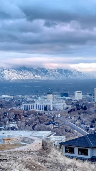 Cosecha vertical Colina con vistas al centro de Salt Lake City y montaña distante polvoreada con nieve — Foto de Stock
