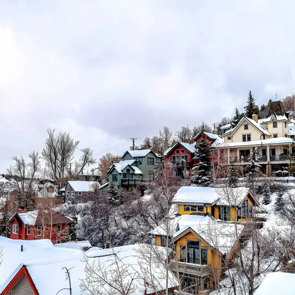 Πλατεία καλλιεργειών Σύννεφα ουρανό πάνω από γραφική γειτονιά κοινότητα φωλιασμένο σε χιονισμένο λόφο έδαφος — Φωτογραφία Αρχείου