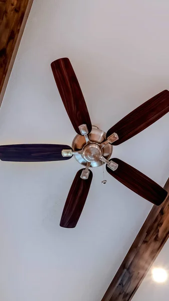 Vertical frame Living room ceiling fan flanked by decorative wood beams and recessed lights — Stock Photo, Image