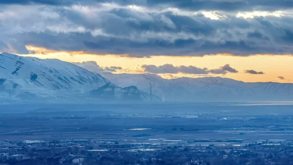 Panorama upraw Salt Lake City Utah krajobraz przed śnieżną górą i zachmurzone niebo o zachodzie słońca — Zdjęcie stockowe