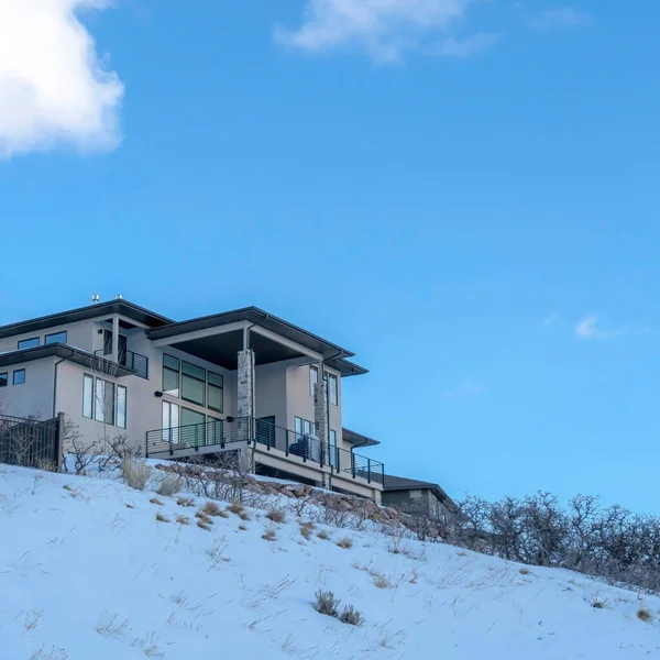 Fachada cuadrada de la casa en la montaña nevada contra el cielo azul y las nubes en invierno — Foto de Stock