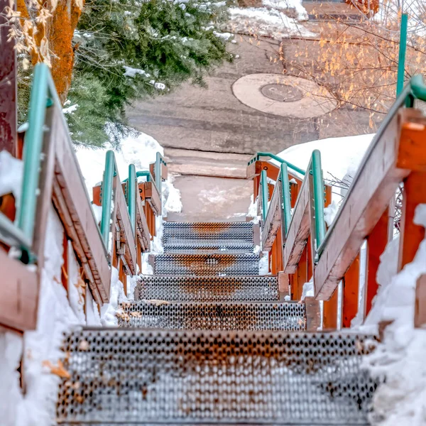 Quadratische Treppe hinunter zu einer Straße auf einem Hügel mit Neuschnee im Winter — Stockfoto