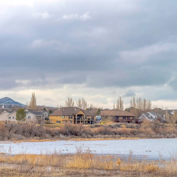 Cielo cuadrado con gruesas nubes grises sobre el paisaje residencial con vistas al paisaje del lago —  Fotos de Stock
