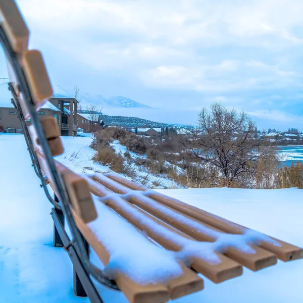 Kwadratowa rama Snowy pagórkowaty teren nad osłoniętym jeziorem Utah zimą z pustą ławką na zewnątrz — Zdjęcie stockowe