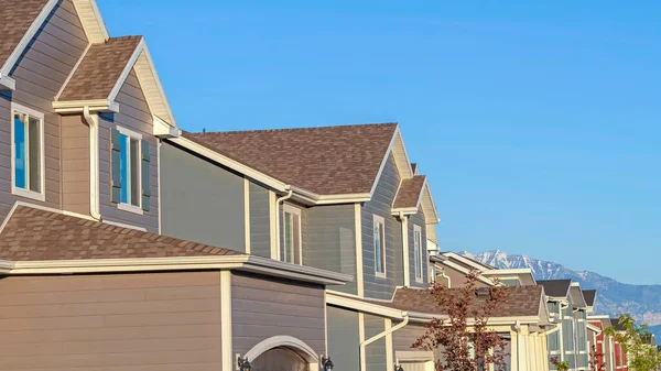 Panorama Fila de casas en un barrio suburbio con fondo de montaña y cielo azul — Foto de Stock