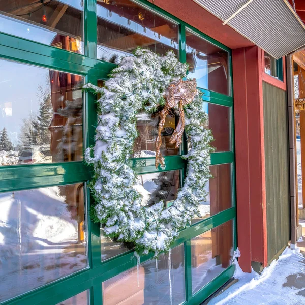 建筑物玻璃墙上的方形结霜花环，反映了冬季的风景 — 图库照片
