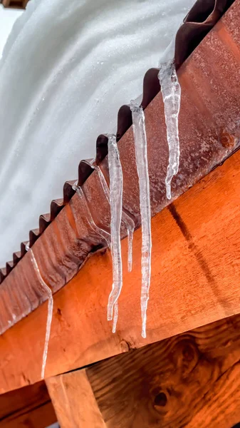 Marco vertical Icicles en el borde del techo de metal corrugado con montículo de nieve fresca en invierno — Foto de Stock