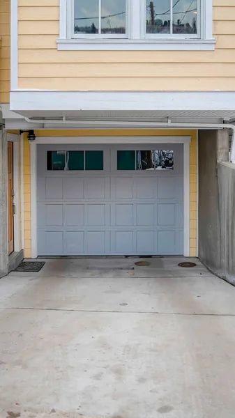 Cadre vertical Maison enneigée avec porte de garage en verre gris lambrissé et escaliers allant au porche — Photo