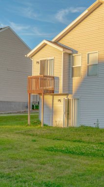 Güneşli bir günde beyaz duvar kaplamalı çatı ve küçük balkon manzaralı Dikey Ev