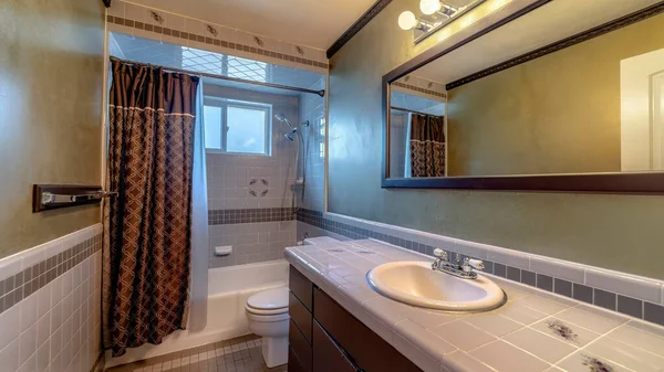 Панорама Плиточный санузел интерьер дома с тщеславной зоной туалет ванна и окно — стоковое фото