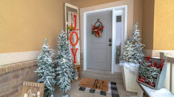 Panorama Festive home entrance with christmas trees holiday decorations and basket wreath — Stock Photo, Image