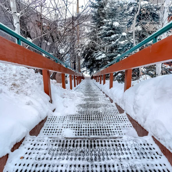 Rejilla cuadrada escalera de pisada con madera y hansrail de metal contra la colina nevada en invierno — Foto de Stock