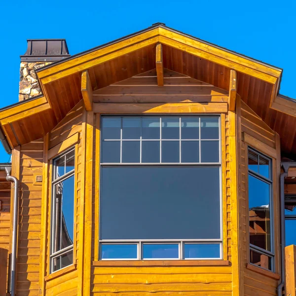 Fachada de casa cuadrada de varios pisos con grandes ventanales y pared exterior de madera — Foto de Stock