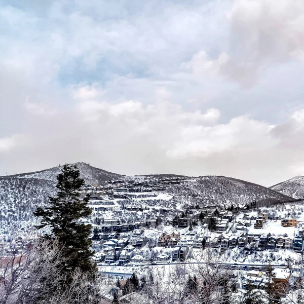 Casas cuadradas que se sientan en una montaña en Park City con árboles perennes y nieve en invierno — Foto de Stock