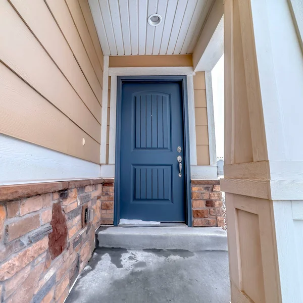 正方形作物家庭立面，门阶和入口有蓝色门板和融化的雪 — 图库照片