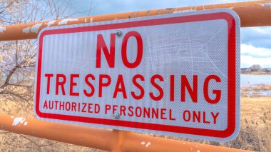 Panorama Mahsulü Uzak göl ve bulutlu gökyüzüne karşı eski metal bir çitte izinsiz giriş yok