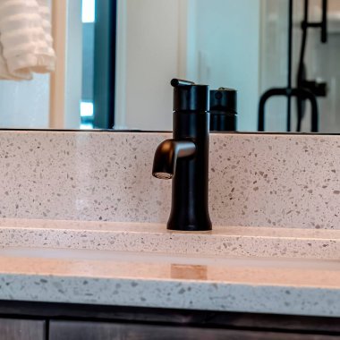 Square Undermount lavabosu, beyaz tezgahın üzerinde siyah musluk ve ev banyosu.