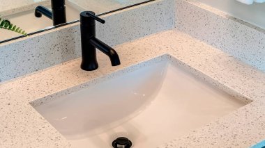 Panorama Banyo beyaz tezgahı, tek bir leğen, lavabo ve siyah musluğu var.