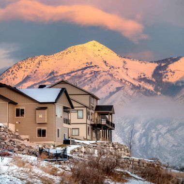 Wasatch Dağları manzaralı tepedeki kare evler ve gün batımında bulutlu gökyüzü