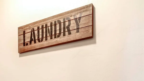 Panorama Laundry room interior with woven basket and decorative wooden sign against wall — Stock Photo, Image