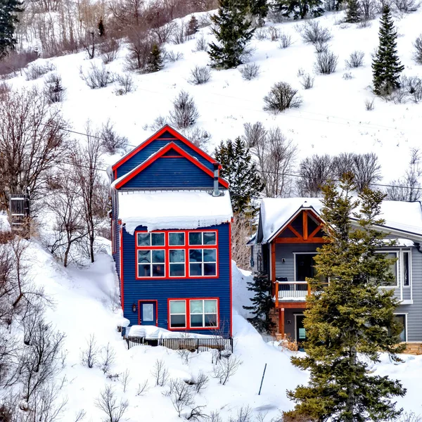 Kwadratowa rama Kolorowe domy sąsiedztwa położone na zboczu zaśnieżonych wzgórz oglądanych w zimie — Zdjęcie stockowe