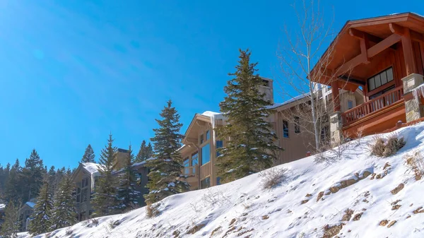 Panorama Façade de belles maisons sur une pente enneigée blanche par une journée d'hiver ensoleillée — Photo