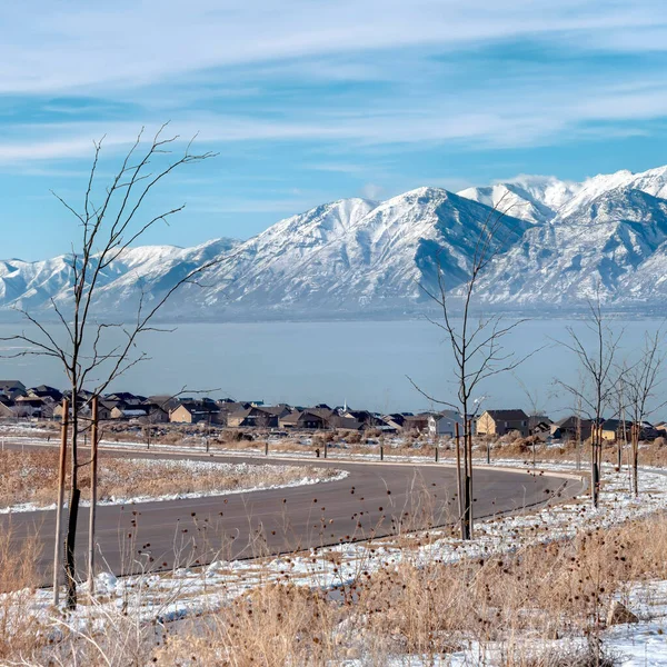 Square Road et maisons ovelooking enneigé Wasatch montagnes et bleu Utah lac en hiver — Photo