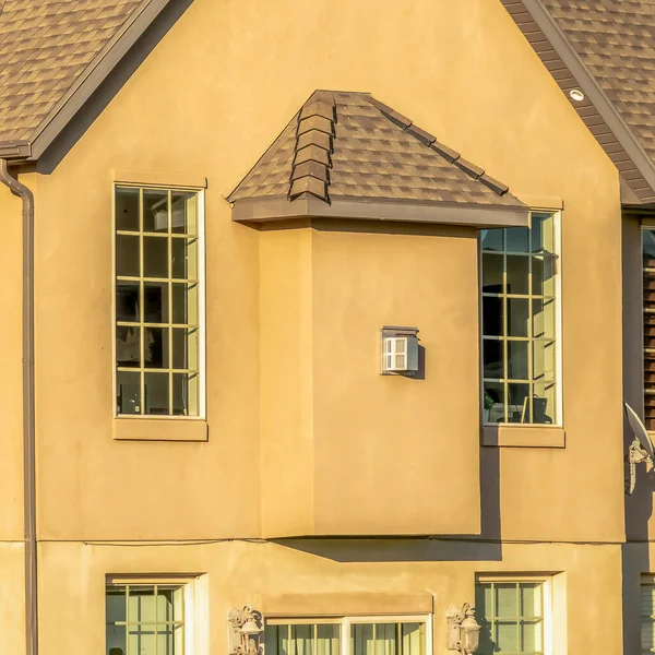 Casa cuadrada con tejas de techo oscuro pared de hormigón marrón y ventanas de cristal de cabaña — Foto de Stock