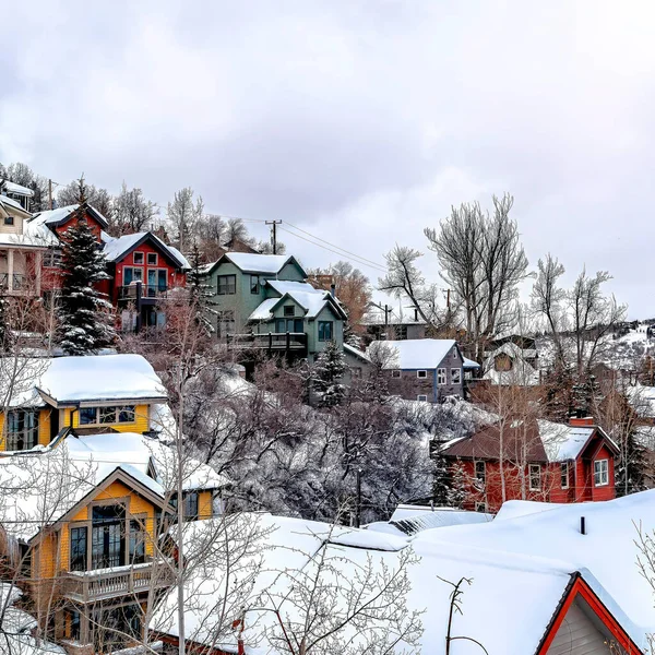 Quadrat Bewölkter Himmel über malerischer Nachbarschaftsgemeinschaft auf schneebedecktem Hügelgelände — Stockfoto