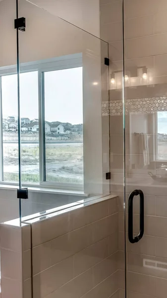 Vertical Frameless walk in shower stall and built in bathtub inside tile wall bathroom