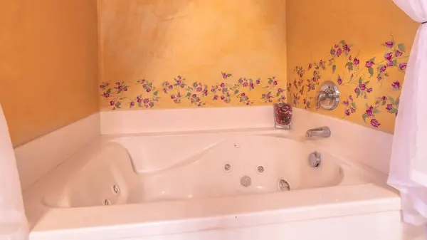 Panorama Ingebouwde witte jacuzzi in een badkamer met bloem ontwerpen aan de muur — Stockfoto
