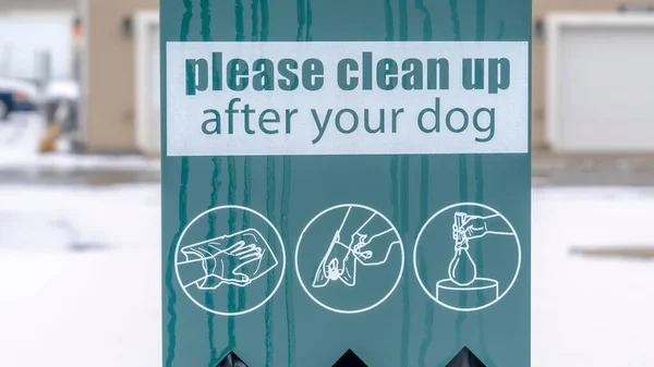 Panorama Pet Waste Station mit schwarzen Hundekotbeuteln gegen verschwommene Häuser und verschneiten Boden — Stockfoto