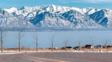 Panorama ekin yolu karlı Wasatch Dağları ve Utah Gölü 'ne bakan genç ağaçlarla dolu.