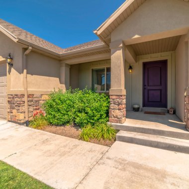 Kare çerçeve Mavi gökyüzüne karşı girişi ve garajı olan evin ön cephesi