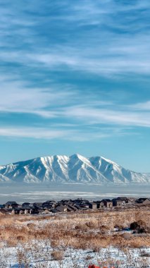 Dikey ekin hasadı engebeli Wasatch Dağları ve buzlu Utah Gölü. Önü karlı.