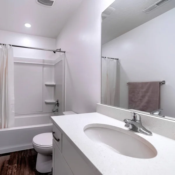 Kare mahsulü. Oval lavabo, ayna, banyo küveti ve duşu olan temiz beyaz banyo. — Stok fotoğraf