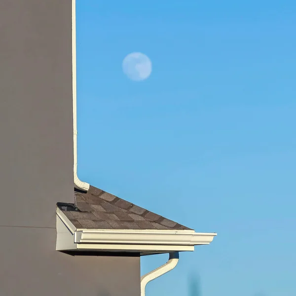 以模糊的月亮和蓝天为背景的房屋外墙的正方形关闭 — 图库照片