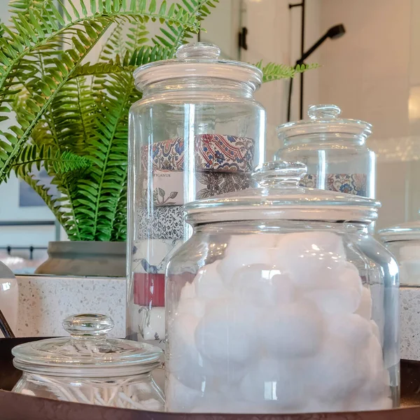 Square Tanaman dan nampan dengan guci bola kapas sabun dan tunas di atas meja kamar mandi — Stok Foto