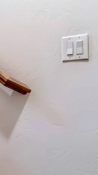 Вертикальний коричневий дерев'яний поручень сходів і перемикач світла на внутрішню стіну — стокове фото