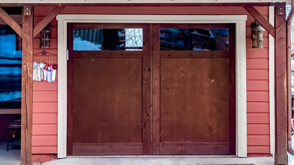 Panorama quadro de vidro de madeira marrom portão de garagem painéis de casa sob telhados nevados no inverno — Fotografia de Stock