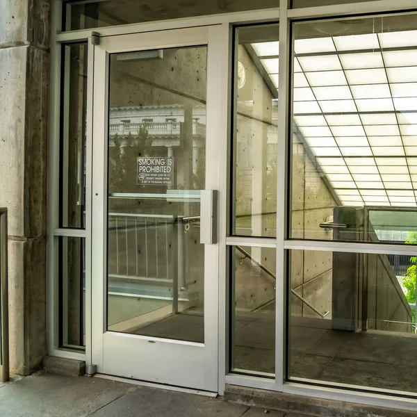 Cultura quadrada Porta e parede de vidro com vista para o telhado fosco inclinado sobre escada de construção — Fotografia de Stock