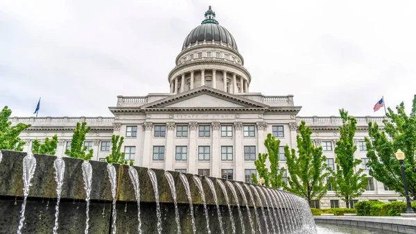 Panorama gröda Cirkulär pool och fontän med Utah State Capital kupol och hindrad byggnad — Stockfoto