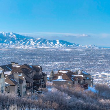 Wasatch Dağları 'na, kışın karlı arazide evleri olan kare kar yağıyor.