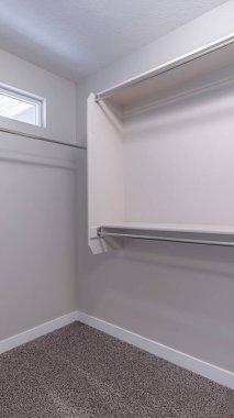 Küçük pencere halısı döşemesi ve beyaz duvarı olan dolap içinde dikey boş yürüyüş