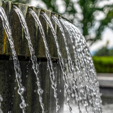 Kare mahsul. Dairesel taş çeşme havuzunu parlak berrak suyla kapatın.