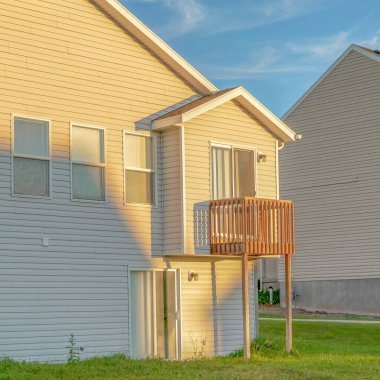 Güneşli bir günde beyaz duvar kenarlı çatı ve küçük balkon manzaralı Square Home.